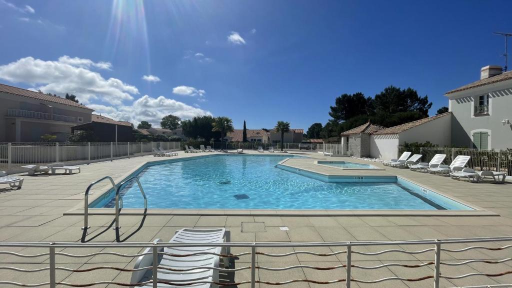 une grande piscine avec des chaises dans une cour dans l'établissement Villa Aquatica Piscine & Plage, à Plage-des-Demoiselles