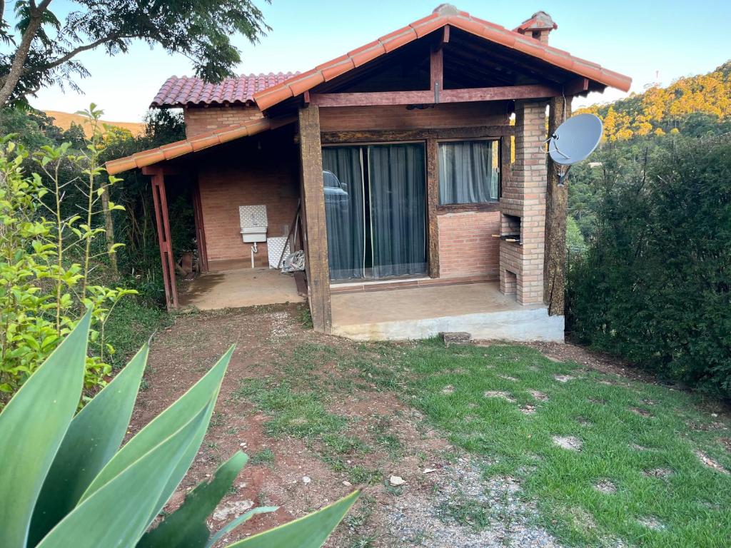 a small house with a window and a yard at Chalé Póca in Conceição da Ibitipoca