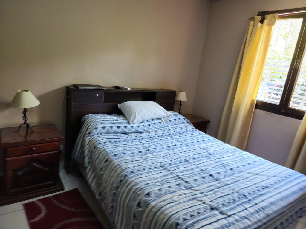 Schlafzimmer mit einem Bett mit einer blauen und weißen Bettdecke in der Unterkunft Salta eco alojamiento in Salta