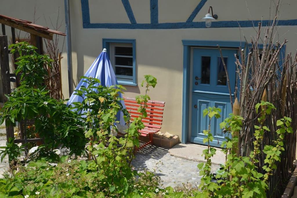 a house with a blue door and an umbrella at Romantische Zeitreise in historischer Käserei in Unlingen