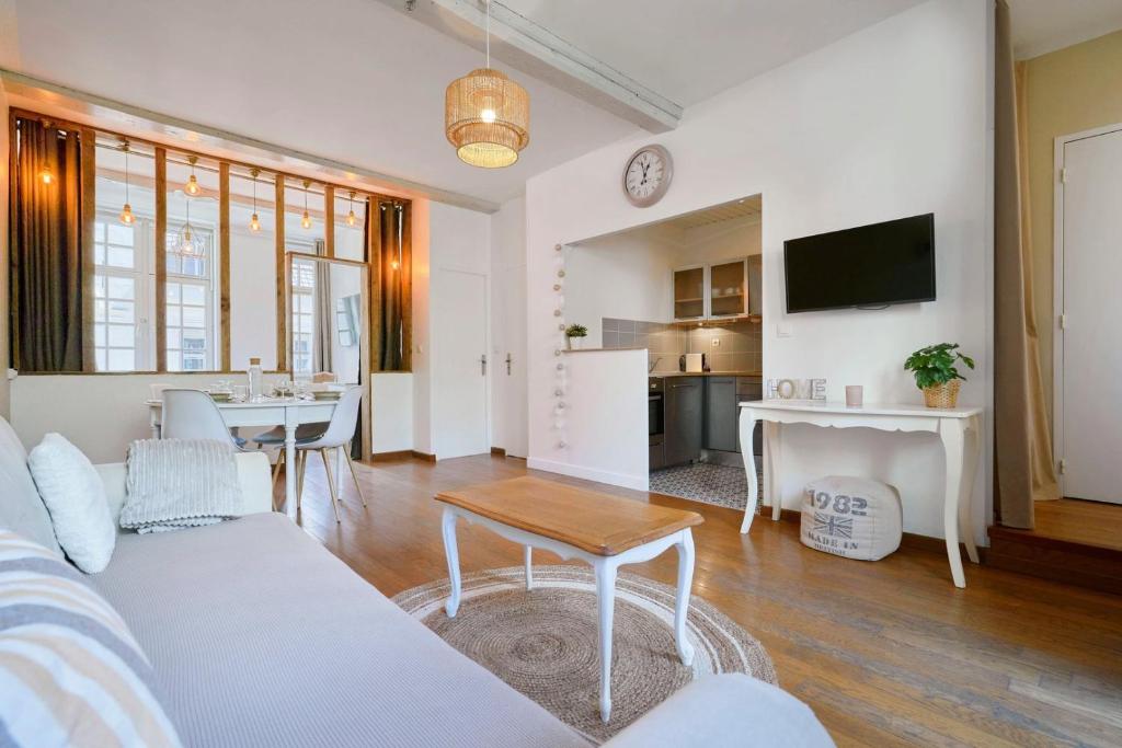 ein Wohnzimmer mit einem Sofa und einem Tisch in der Unterkunft Charming 2 bedroom apartment with terrace in Lille