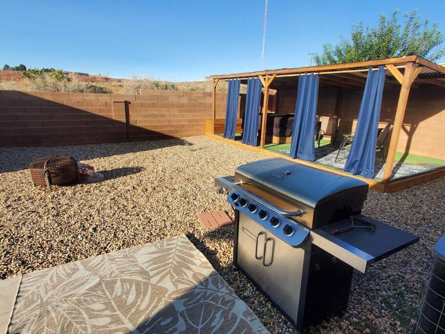 a barbecue grill in a yard with a house at I Deal Lake Powell Home 3BR, Jacuzzi, BBQ, Firepit in Page
