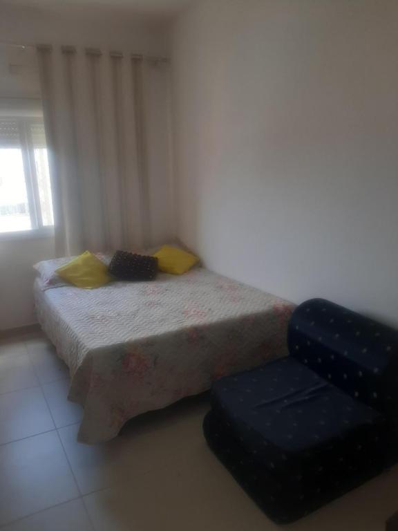 - une petite chambre avec un lit et une chaise dans l'établissement Apartamento disponível 1 dormitório, à Tramandaí