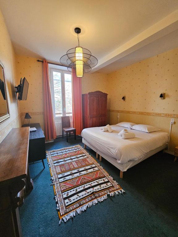 a bedroom with a large bed and a chandelier at Auberge "La Petite Auberge" in Bourg-Saint-Maurice