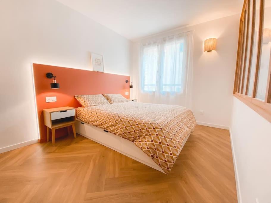 - une chambre avec un grand lit et une tête de lit orange dans l'établissement Appartement climatisé Vieux Port, rénové et cosy, à Marseille