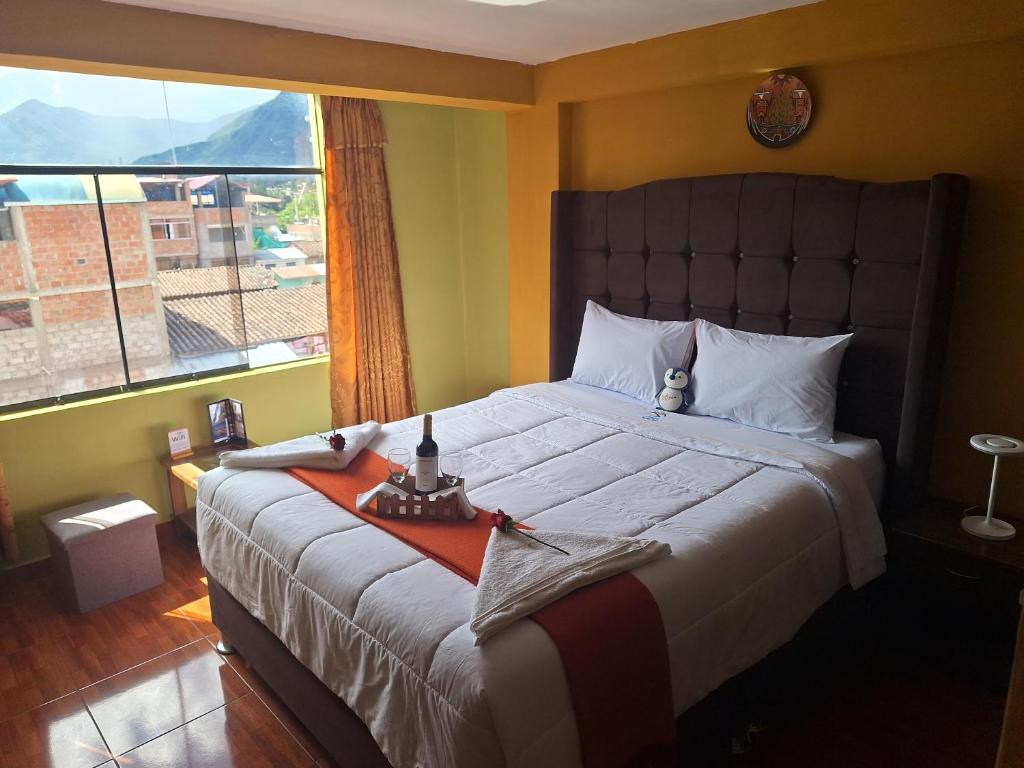 a bedroom with a large bed with a large window at Chaska valle Inn in Urubamba