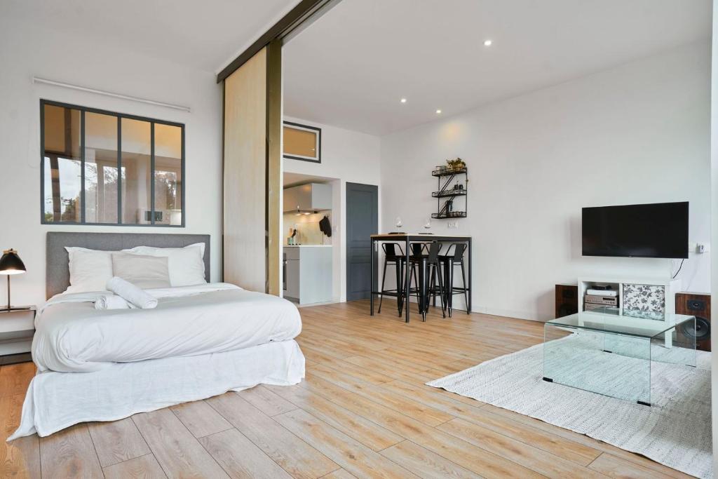 une chambre blanche avec un lit et une table dans l'établissement Charming and quiet apartment on the main boulevard, à La Madeleine