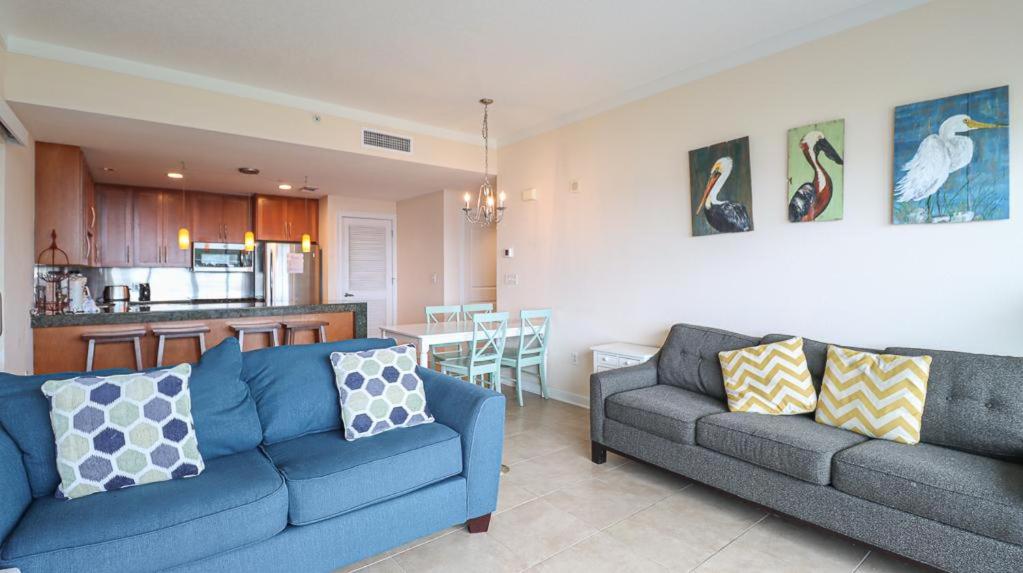 ein Wohnzimmer mit 2 blauen Sofas und einer Küche in der Unterkunft Ocean Club 308 in Biloxi
