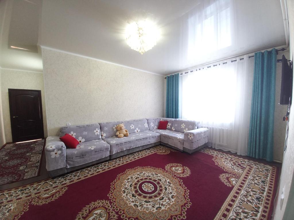 ein Wohnzimmer mit einem Sofa und einem großen Fenster in der Unterkunft Askar Guesthouse in Karakol