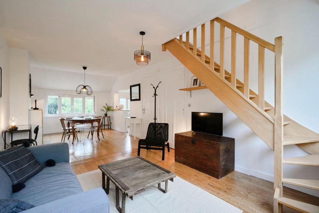 a living room with a blue couch and a staircase at Superbe appartement art deco tout équipé pour 2 ! in Marcq-en-Baroeul
