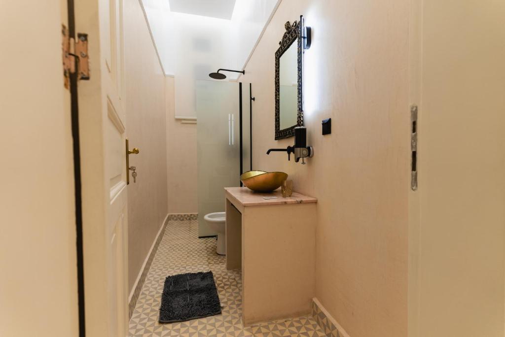 a bathroom with a sink and a toilet and a mirror at Villa Clio, a Luxury Collection in Thessaloniki