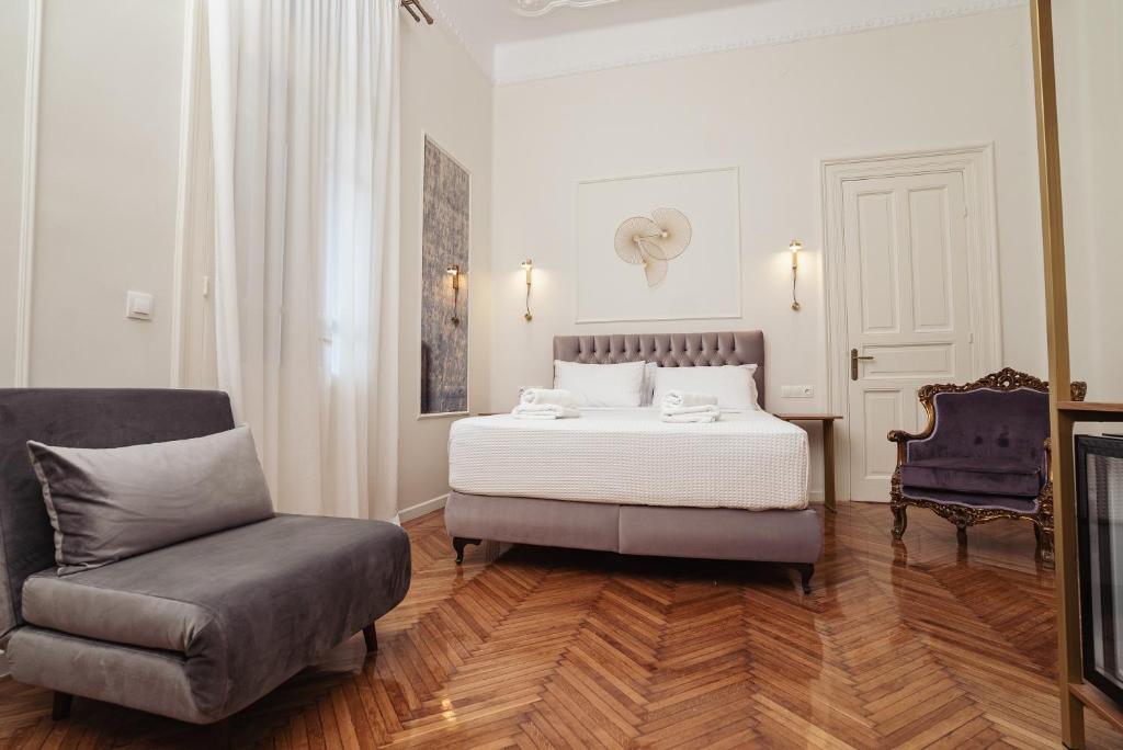 a bedroom with a bed and a couch and a chair at Villa Clio, a Luxury Collection in Thessaloniki