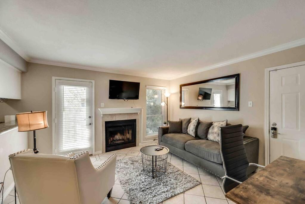 a living room with a couch and a fireplace at I12 - DFW Grd Flr Modern Furn. Condo 2BD1BA in Irving