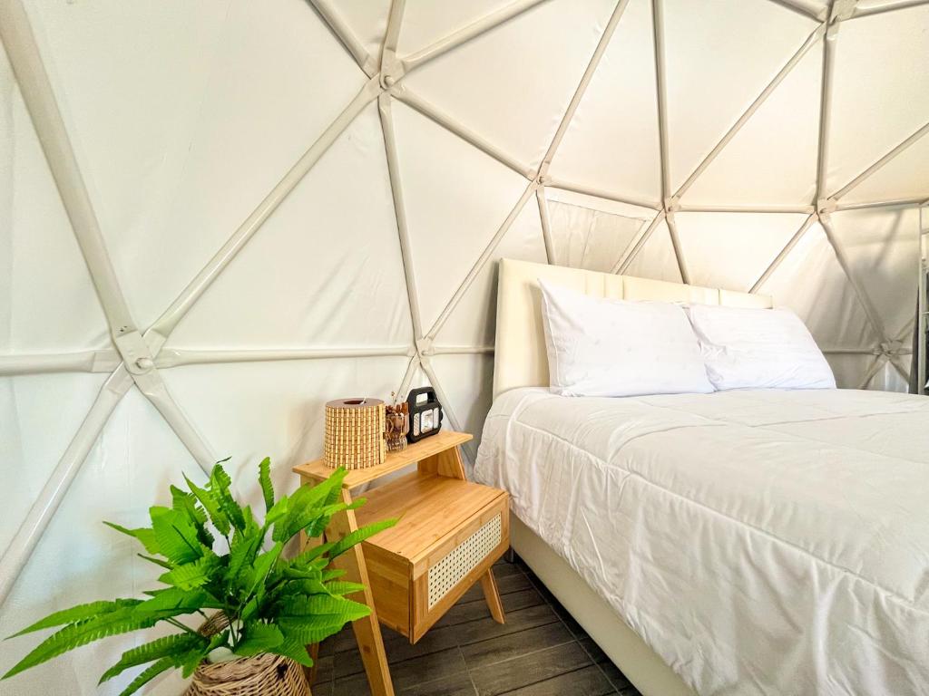 a bedroom with a bed in a triangular tent at EK-KA-NAKE ( เอกขเนก ) in Ko Larn