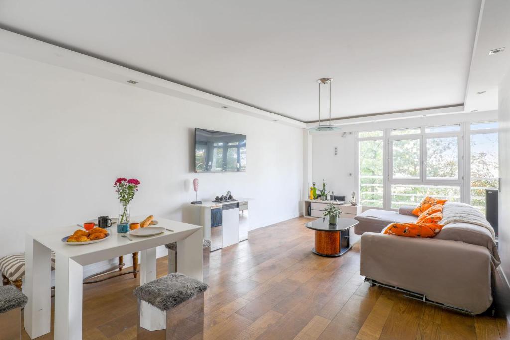 un salon avec un canapé et une table dans l'établissement Appartement Rodina - Welkeys, à Issy-les-Moulineaux