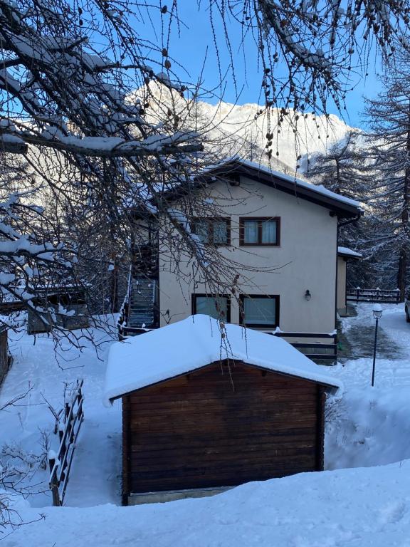 uma casa com um telhado coberto de neve em Green Mountain Lodge em Sauze dʼOulx