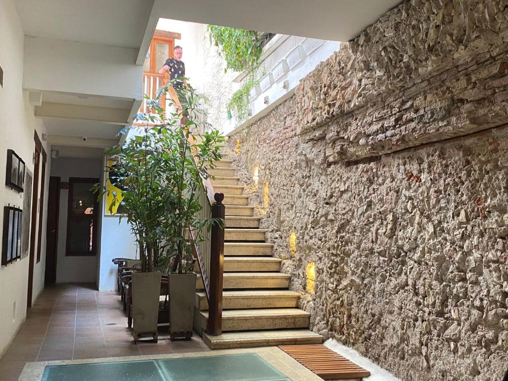 una scala che porta a un edificio con un muro di pietra di Casa Ebano 967 a Cartagena de Indias