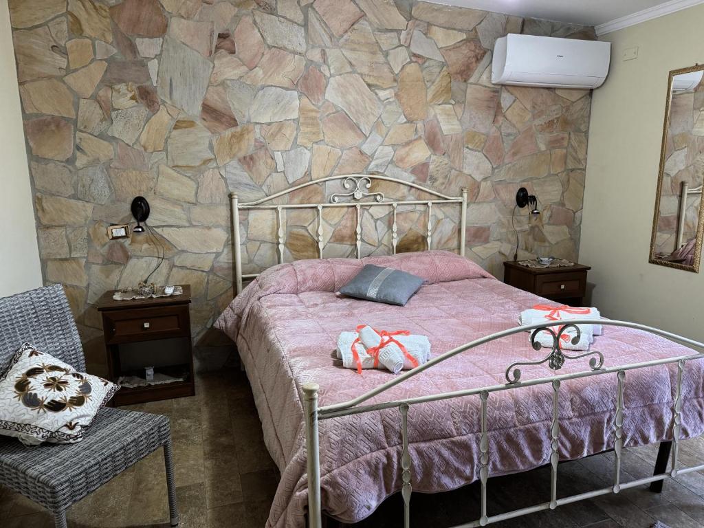 a bedroom with a bed and a stone wall at Perriera House in Sciacca