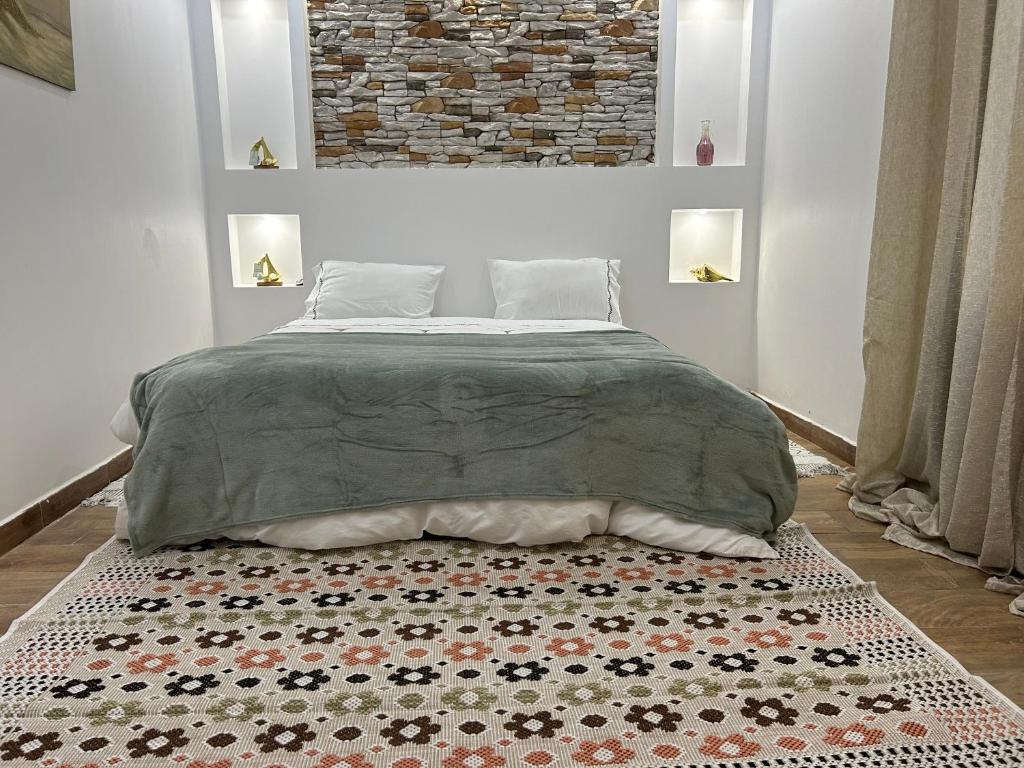 a bedroom with a bed and a rug at Villa la crête in Bejaïa