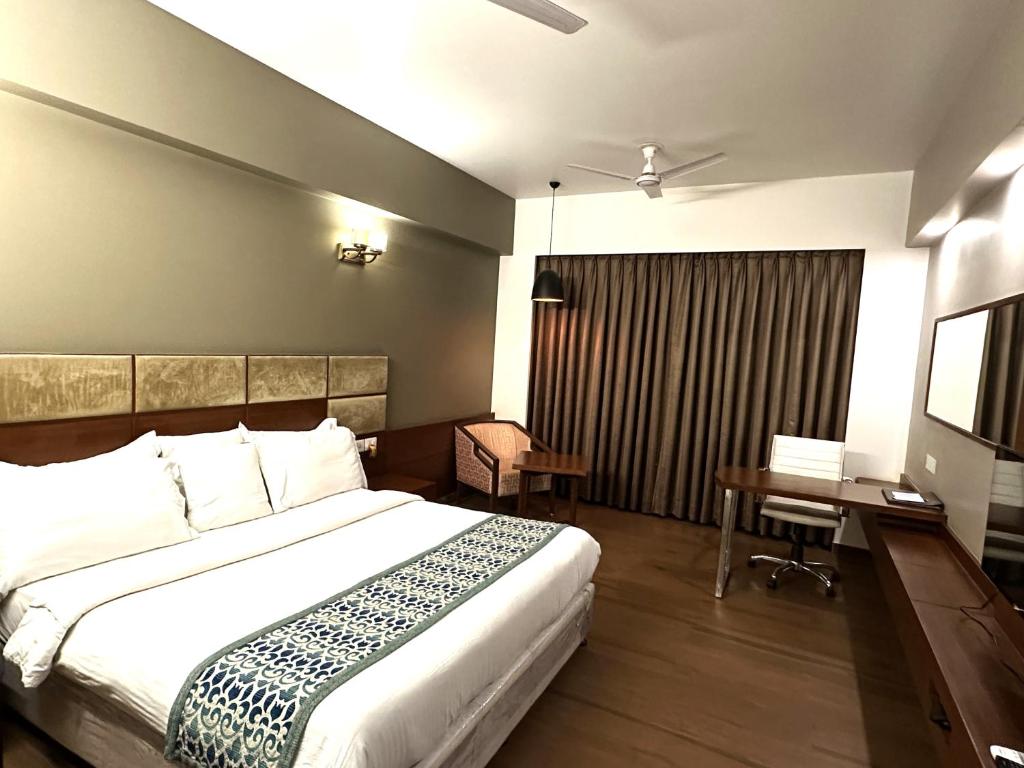 a hotel room with a bed and a desk and a bed at Hotel Yuvraj Dx in Pipra Dewās