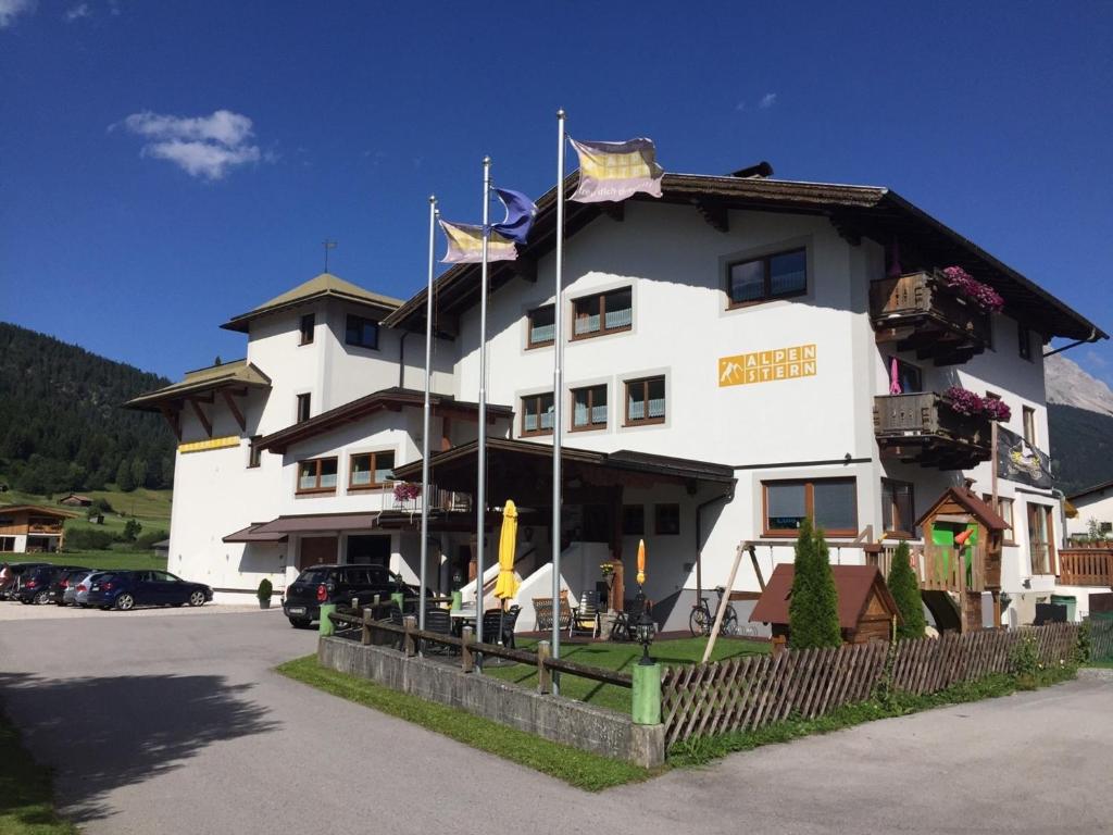 een groot wit gebouw met vlaggen erop bij Zugspitze 6,7 in Lermoos