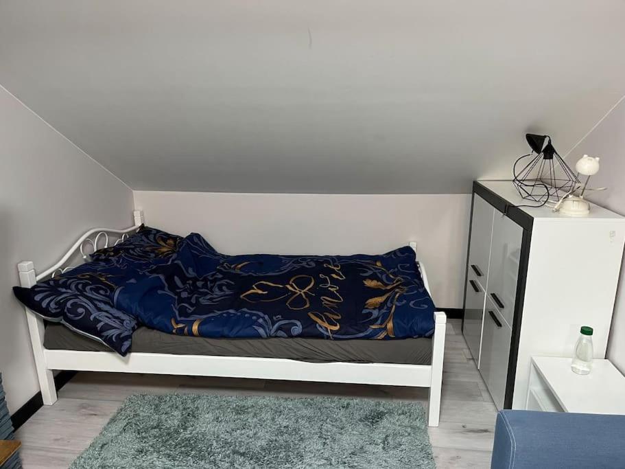 1 dormitorio con 1 cama con manta azul y vestidor en Wola Studio Flat near Progresia en Varsovia