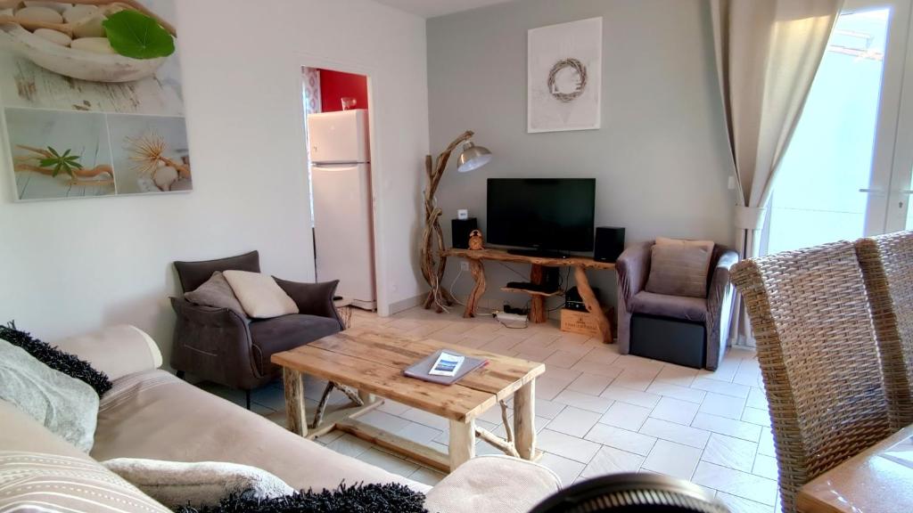ein Wohnzimmer mit einem Sofa und einem Tisch in der Unterkunft Galets Blancs Yourhosthelper in Royan
