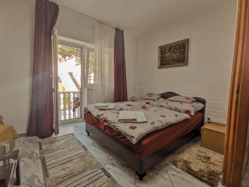 ヘーヴィーズにあるHévíz Kristály Apartmanのベッドルーム1室(ベッド1台付)、バルコニーへのドアが備わります。