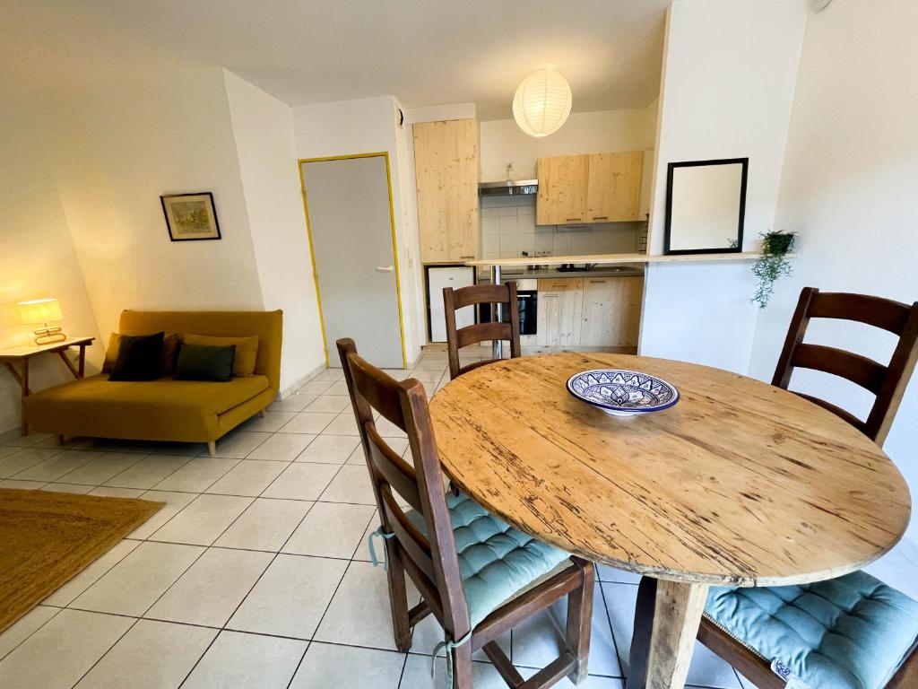 une cuisine et une salle à manger avec une table et des chaises en bois dans l'établissement Bel appartement sur les hauts de Collioure, à Collioure