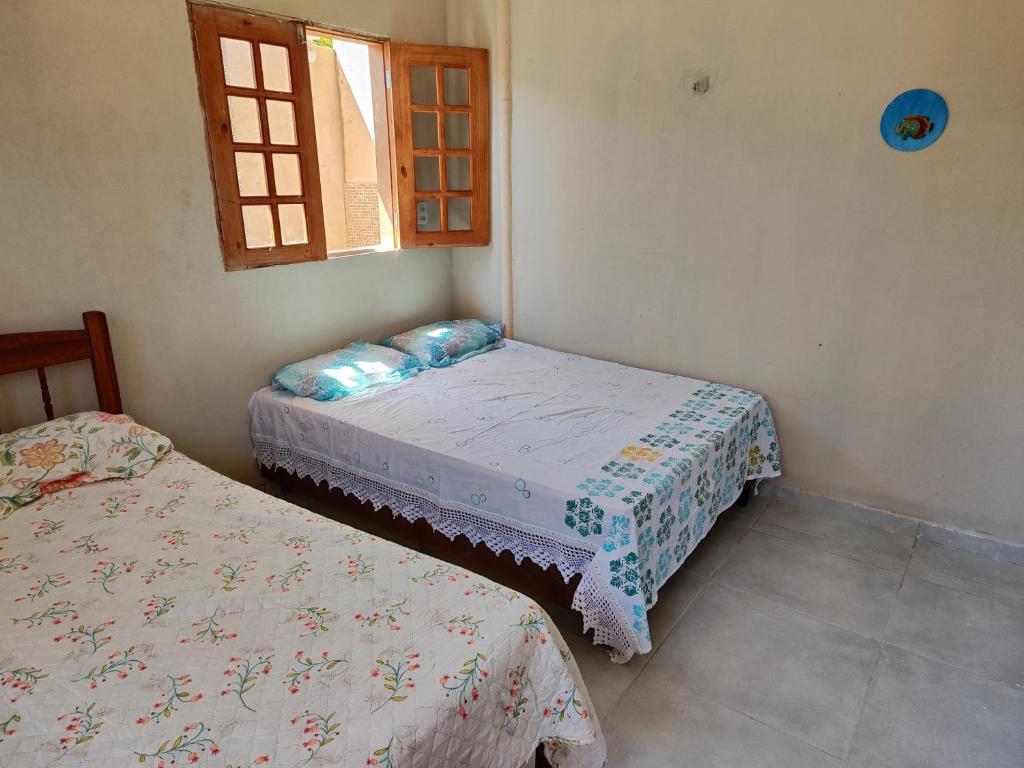 a bedroom with two beds and a window at Kitnet Tibau in Tibau