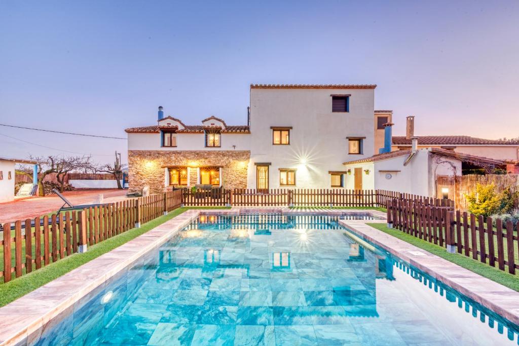 a home with a swimming pool in front of a house at Luxe Mediterranean Masia BBQ Pool Chillout 