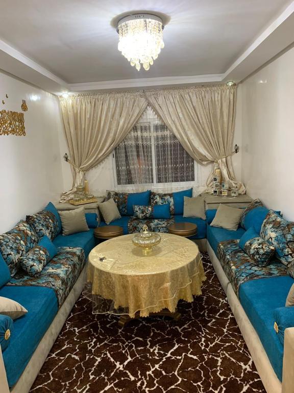 een woonkamer met een blauwe bank en een tafel bij agadir hay salam in Agadir