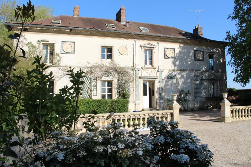 een oud huis met een hek ervoor bij Domaine De Marguerite in Janvry