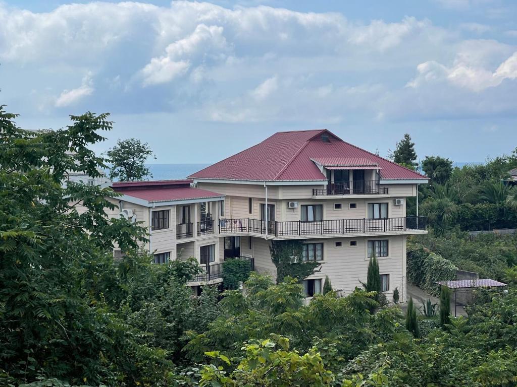 ein großes weißes Haus mit rotem Dach in der Unterkunft SV Hotel Batumi in Makhinjauri