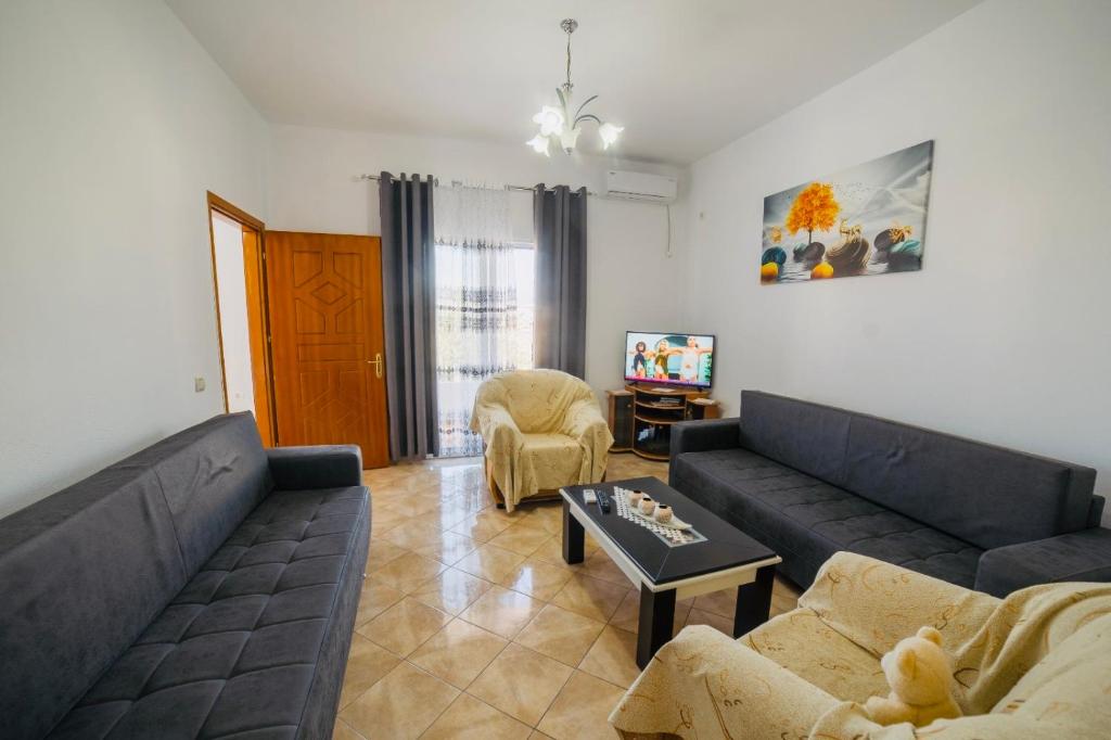 ein Wohnzimmer mit einem Sofa und einem Tisch in der Unterkunft Vila Feimi in Ksamil
