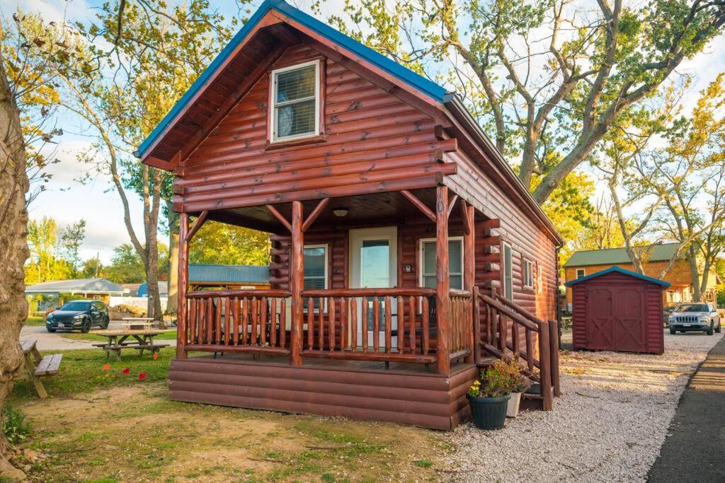 eine kleine Holzhütte mit einer Veranda und einer Bank in der Unterkunft Charming Lakeview Cabin Near Geneva-On-The-Lake! in Ashtabula