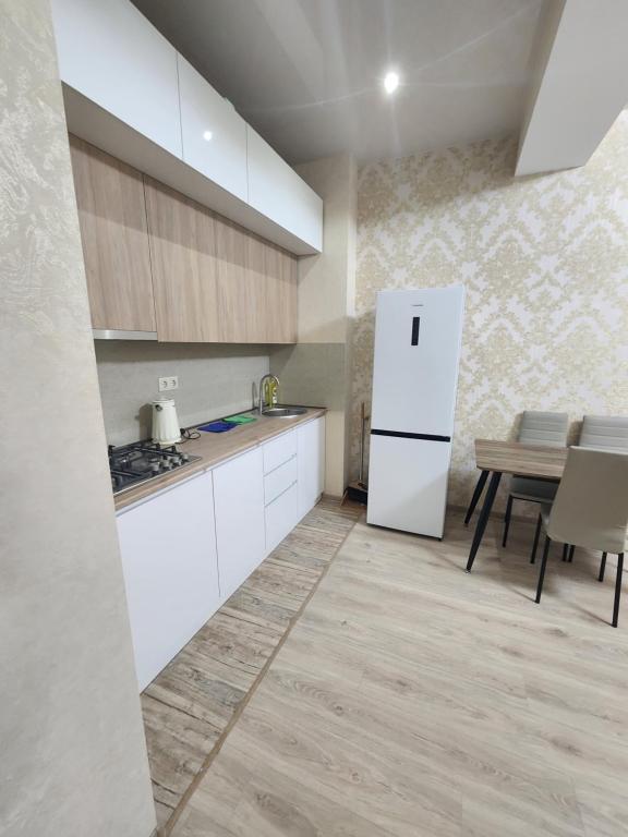 eine Küche mit einem weißen Kühlschrank und einem Tisch in der Unterkunft Dom in Tbilisi City
