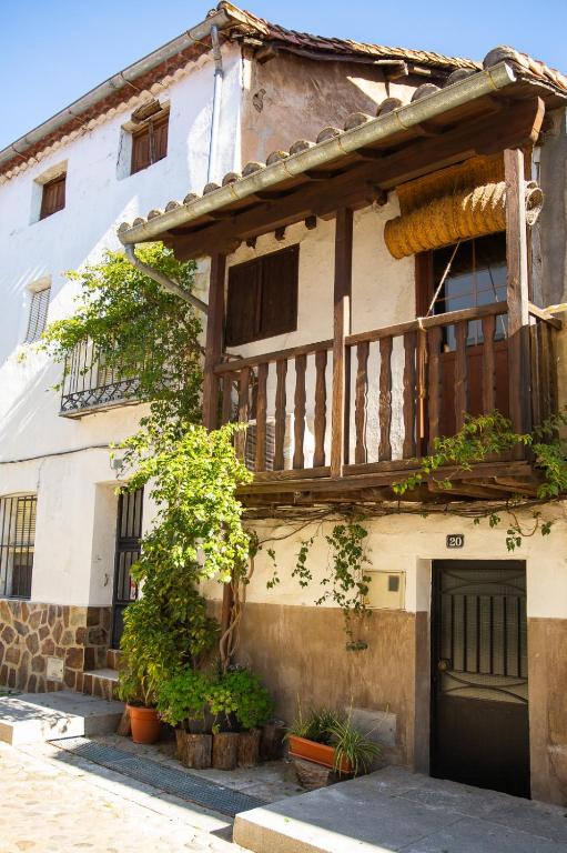 a house with a wooden balcony on the side of it at LA CASITA DE LA CORREDERA in Candeleda