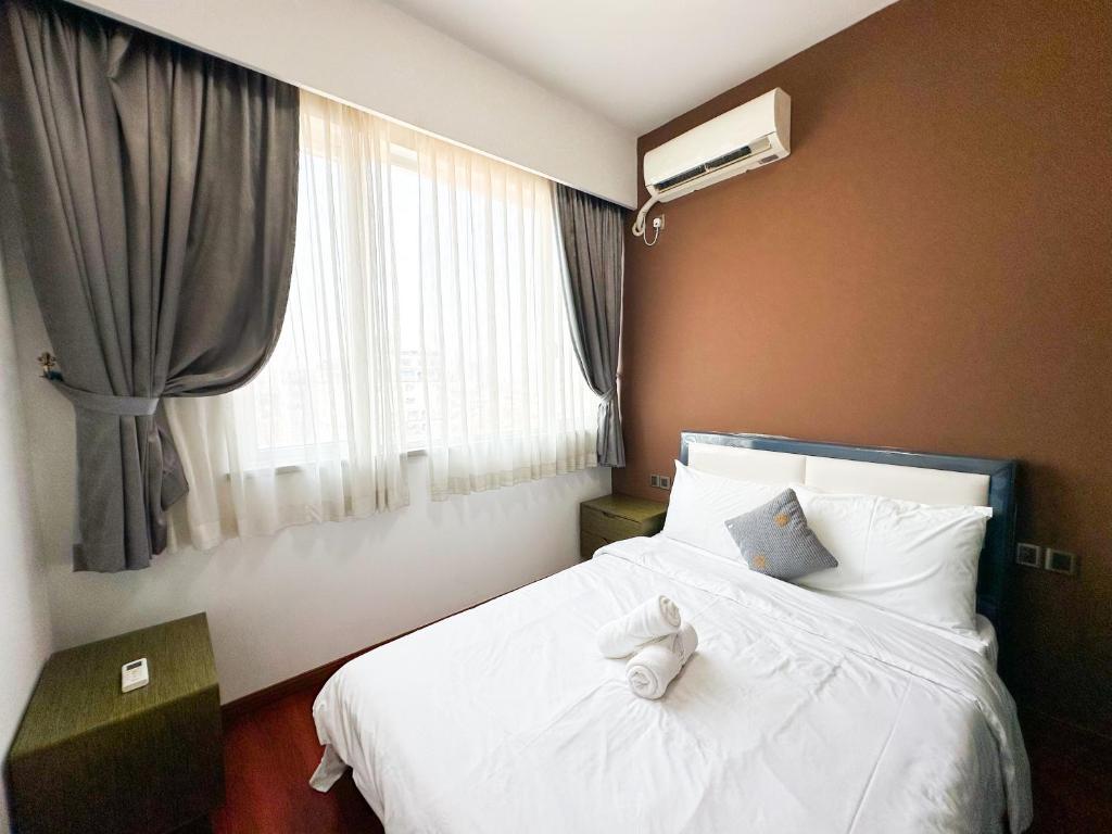 1 dormitorio con 1 cama con sábanas blancas y ventana en Urban Village Residence by Soben Homes en Phnom Penh