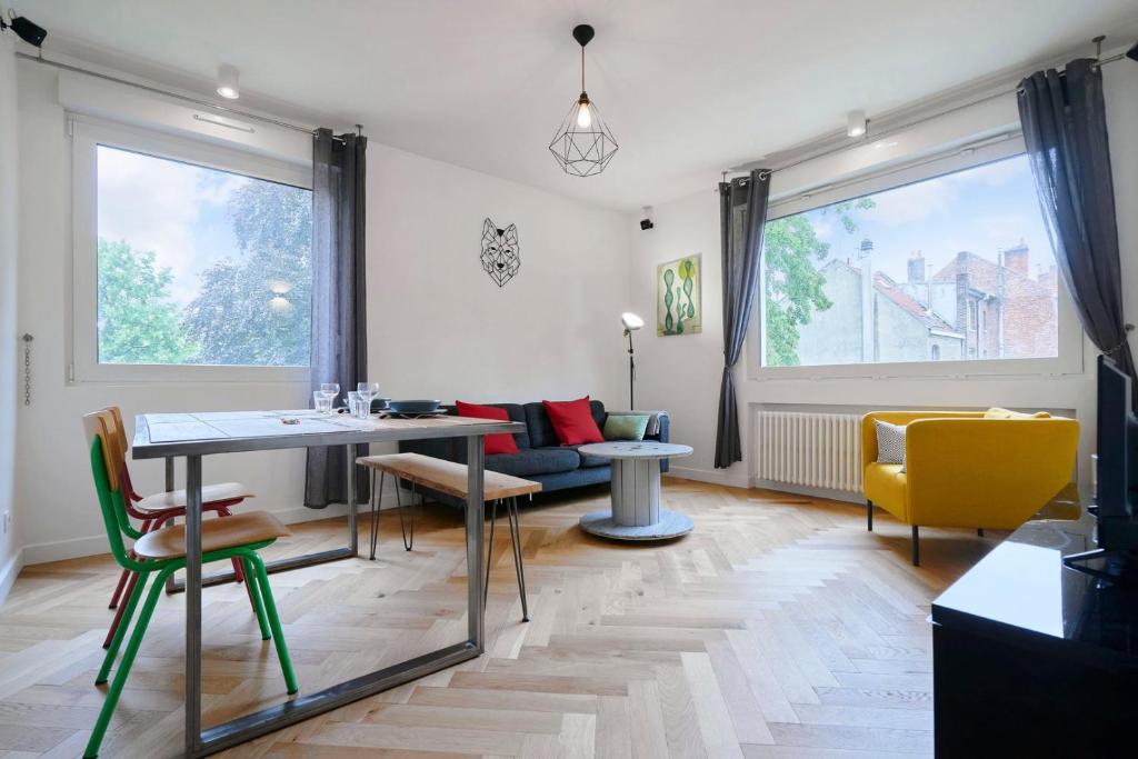 un salon avec une table et des chaises jaunes dans l'établissement Lille République - 2ch très lumineux + Parking !, à Lille