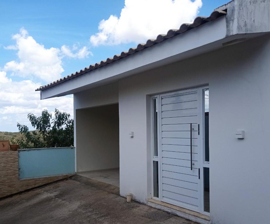 a white house with a large garage door at Casa de Esquina Nova in Garanhuns