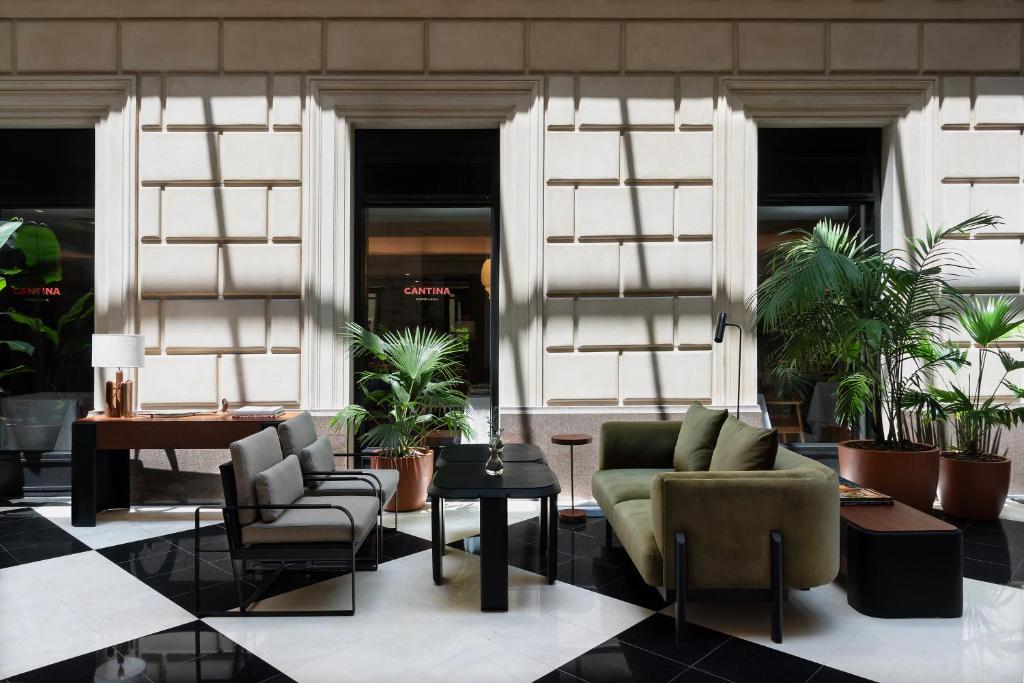 een lobby met stoelen, tafels en planten bij Hotel Casa Lucia in Buenos Aires