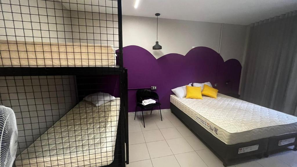 a bedroom with a bed with a purple headboard at Belô Hostel in Belo Horizonte
