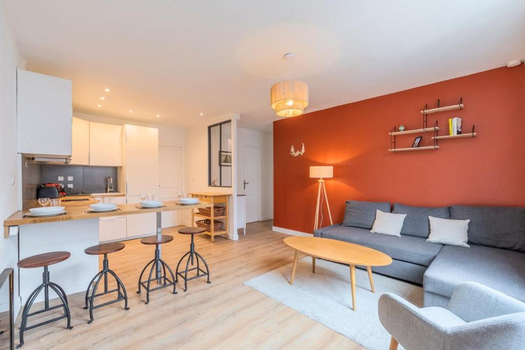 un salon avec un canapé bleu et une cuisine dans l'établissement Lille Hypercentre / Gares - Superbe T2 équipé, à Lille