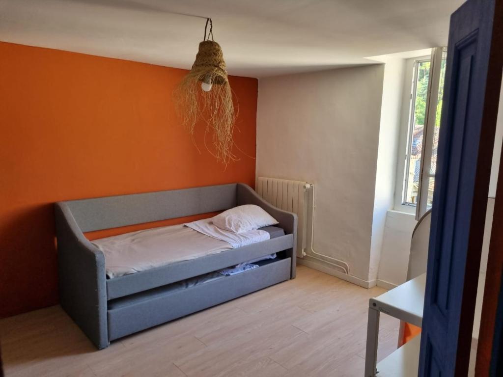 Bett in einem Zimmer mit orangefarbener Wand in der Unterkunft Casa Luna in Lunas