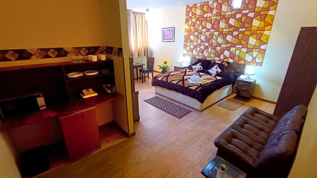 a room with a bed and a living room with a couch at HGA-Diamante-Spa in La Paz