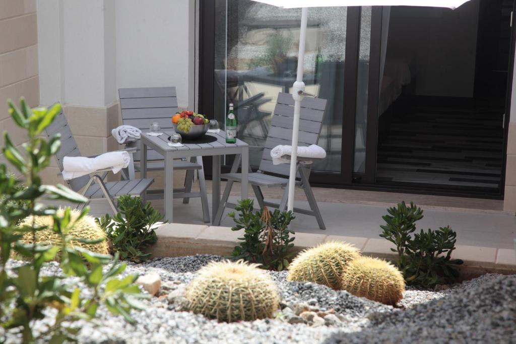a patio with two chairs and a table and cactus at Residenza RoMa in Tropea
