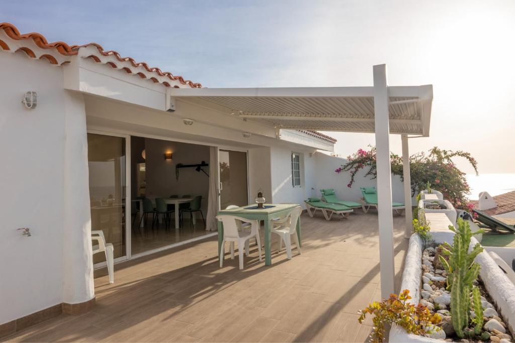 a house with a patio with a table and chairs at Calala House with huge terrace in Candelaria