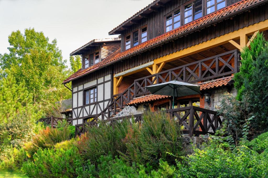 a large building with an umbrella in front of it at Willa Szara Sowa in Stare Juchy