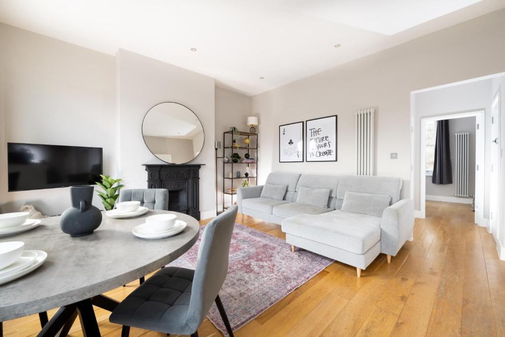 ein Wohnzimmer mit einem Tisch und einem Sofa in der Unterkunft Stylish & Modern London Apartment in Honor Oak in London